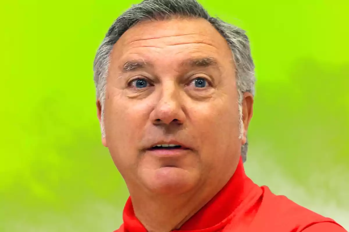 Hombre con camisa roja sobre fondo verde.