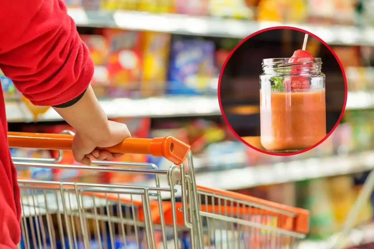 Detalle de carro siendo empujado en una calle borrosa de supermercado, por alguien que lleva una sudadera roja remangada. Bote abierto de gazpacho con fresas en un círculo rojo en la esquina superior derecha de la imagen.