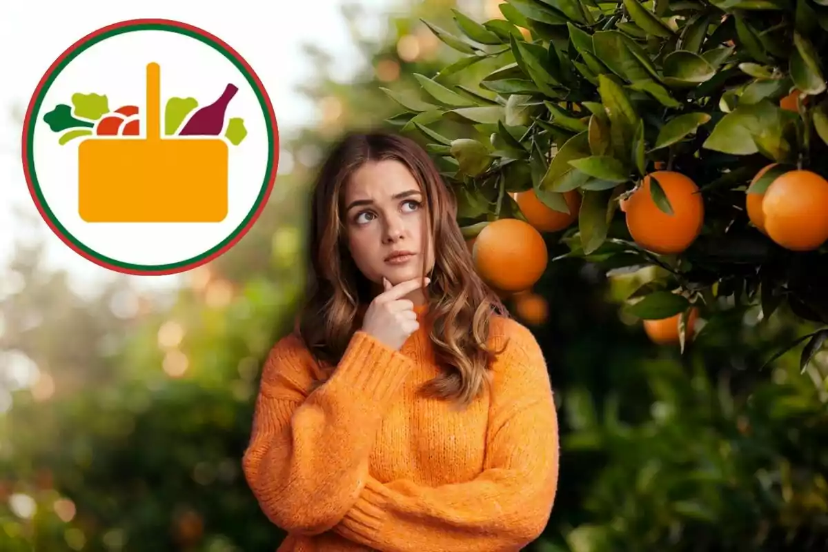 Una mujer con un suéter naranja está pensativa junto a un árbol de naranjas, con un logotipo de una cesta de alimentos en la esquina superior izquierda.