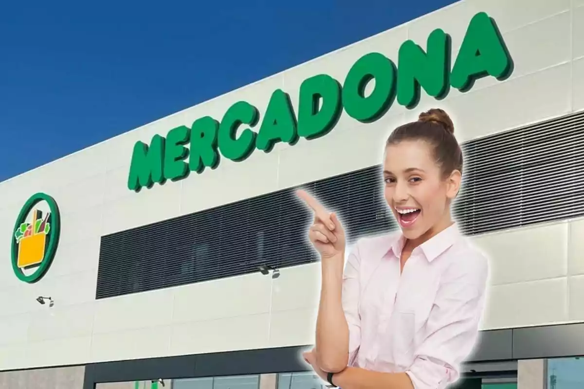 Una mujer sonriente señalando el letrero de Mercadona en la fachada de un edificio.