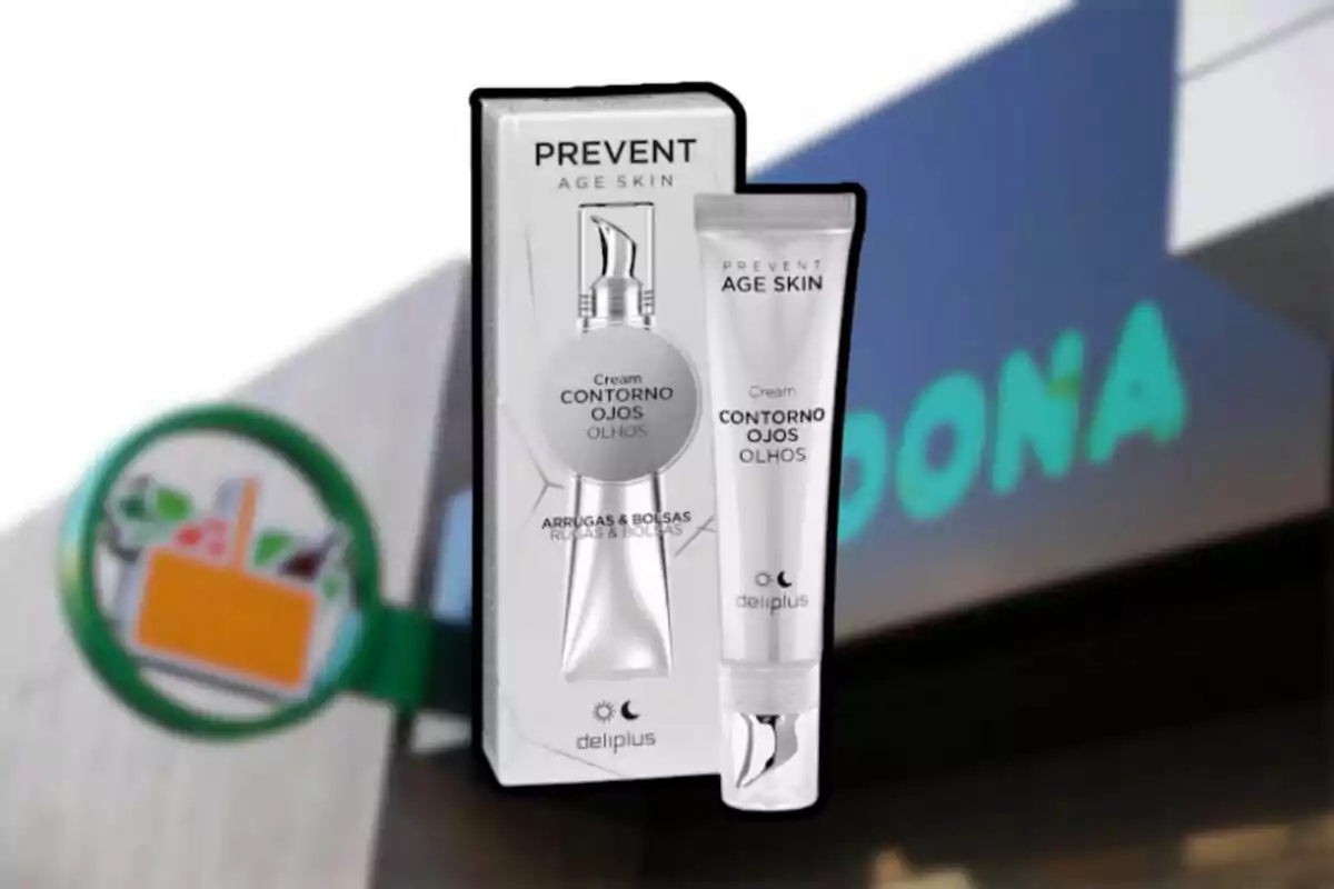 Envase de crema para el contorno de ojos de la marca Deliplus frente a un cartel de supermercado. Envase de crema para el contorno de ojos de la marca Deliplus frente a un cartel de supermercado.