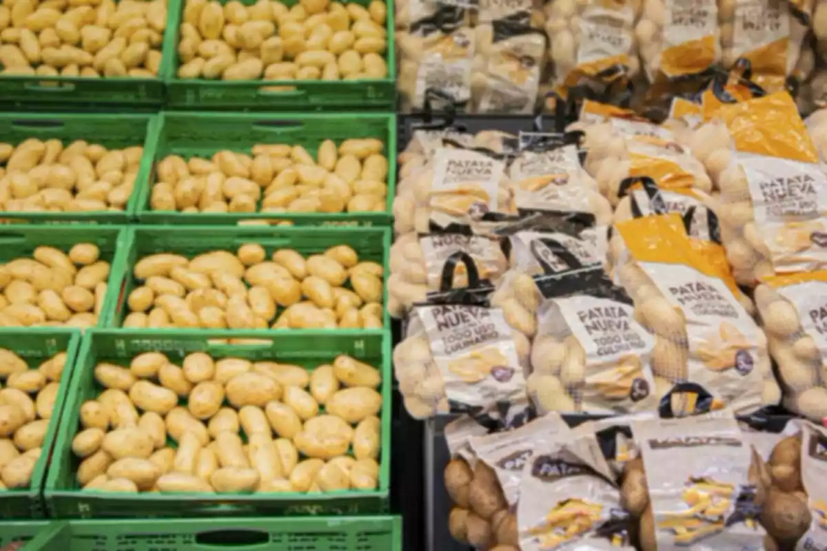 Papas frescas en cajas verdes junto a bolsas de papas empacadas en un supermercado Papas frescas en cajas verdes junto a bolsas de papas empacadas en un supermercado