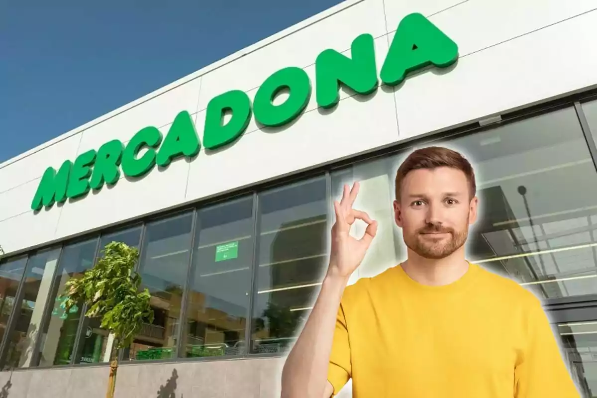 Un hombre con camiseta amarilla hace un gesto de "OK" frente a una tienda de Mercadona.