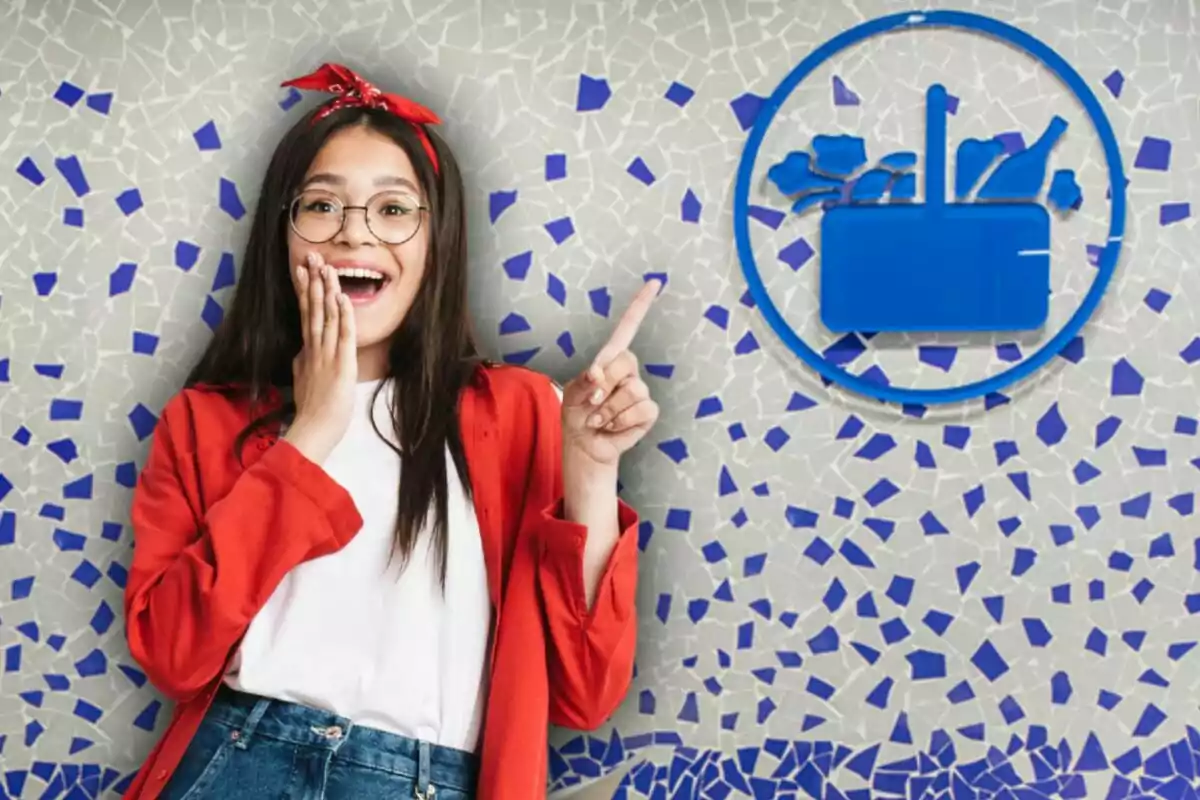 Joven con gafas y pañuelo rojo en la cabeza sonríe sorprendida y señala un símbolo azul de supermercado sobre un fondo de mosaico azul y gris