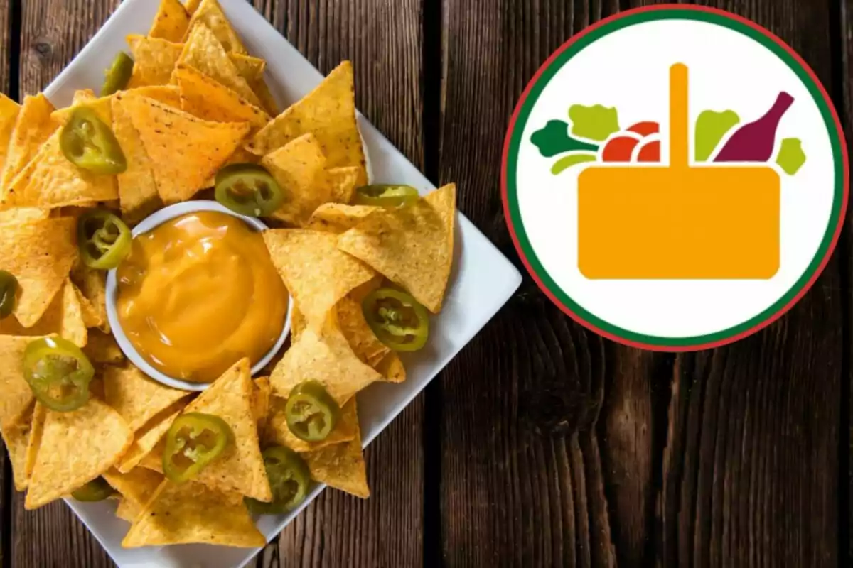 Un plato de nachos con jalapeños y salsa de queso junto a un logotipo de una canasta de alimentos sobre una mesa de madera. Un plato de nachos con jalapeños y salsa de queso junto a un logotipo de una canasta de alimentos sobre una mesa de madera.