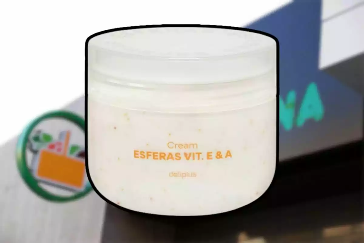 Envase de crema Deliplus Esferas Vitamina E y A frente a una tienda Mercadona desenfocada Envase de crema Deliplus Esferas Vitamina E y A frente a una tienda Mercadona desenfocada