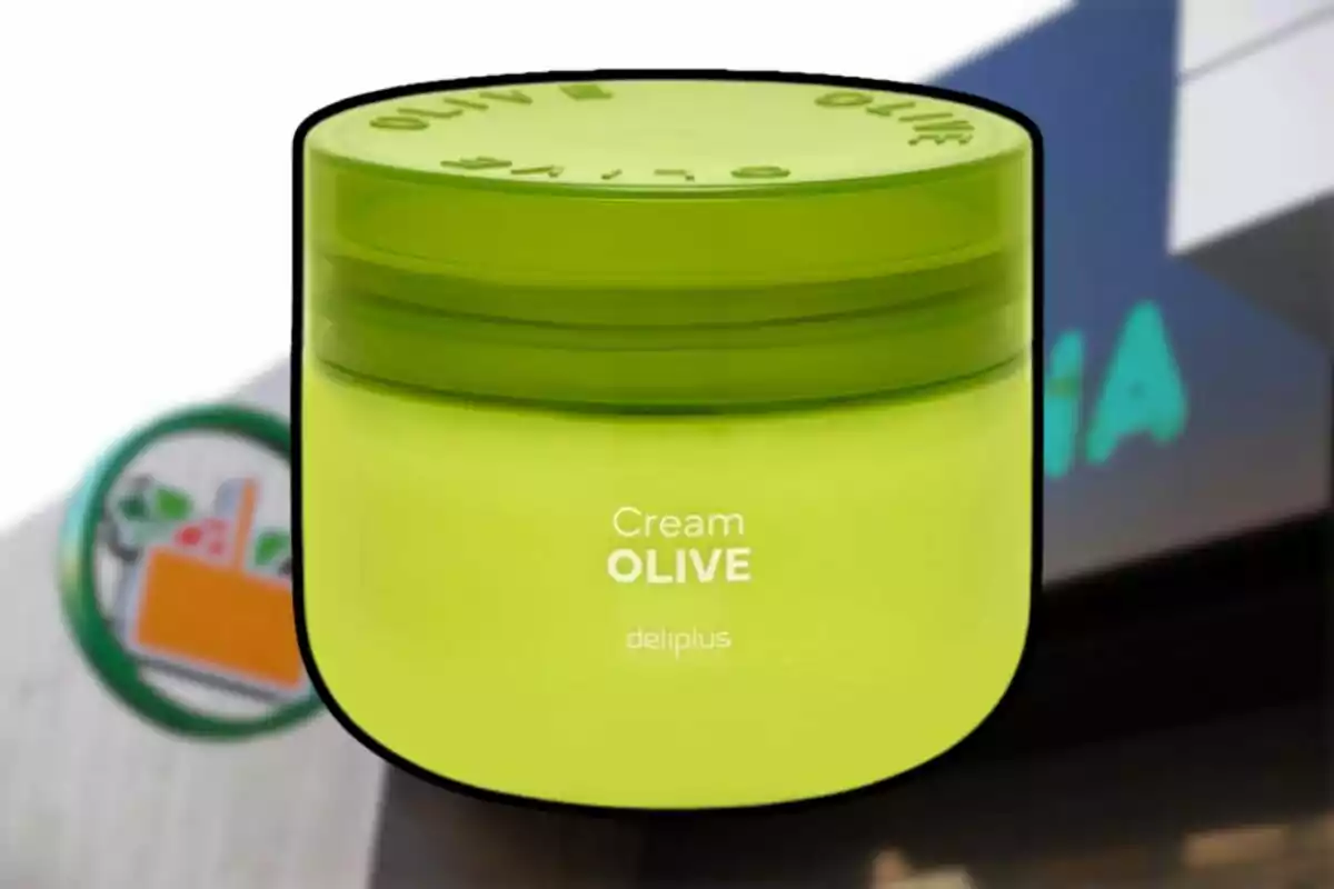 Envase verde de crema hidratante Olive de la marca Deliplus frente a una tienda Mercadona desenfocada. Envase verde de crema hidratante Olive de la marca Deliplus frente a una tienda Mercadona desenfocada.