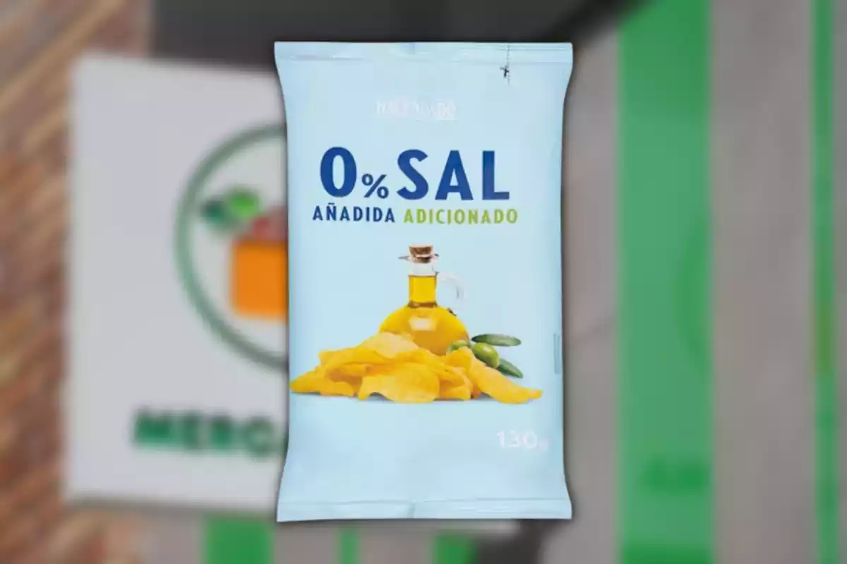 Montaje con el logo de Mercadona de fondo y la bolsa de patatas 0% sal añadida de la marca Hacendado Montaje con el logo de Mercadona de fondo y la bolsa de patatas 0% sal añadida de la marca Hacendado