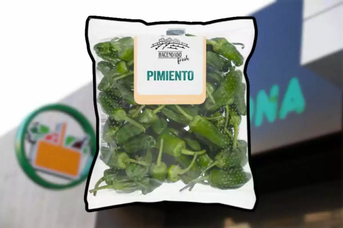 Bolsa de pimientos verdes de la marca Hacendado frente a una tienda Mercadona desenfocada Bolsa de pimientos verdes de la marca Hacendado frente a una tienda Mercadona desenfocada