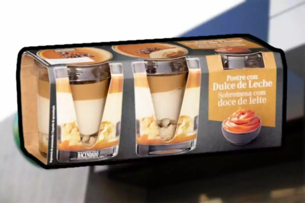 Empaque de postres de dulce de leche en vasos individuales con capas visibles de crema y galleta. Empaque de postres de dulce de leche en vasos individuales con capas visibles de crema y galleta.