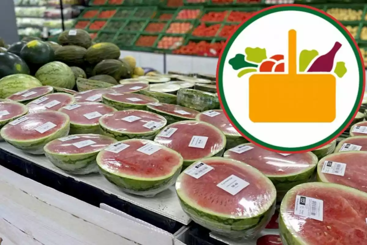 Una sección de frutas en un supermercado con sandías cortadas y envueltas en plástico, junto a un logotipo de una cesta de compras con frutas y verduras.