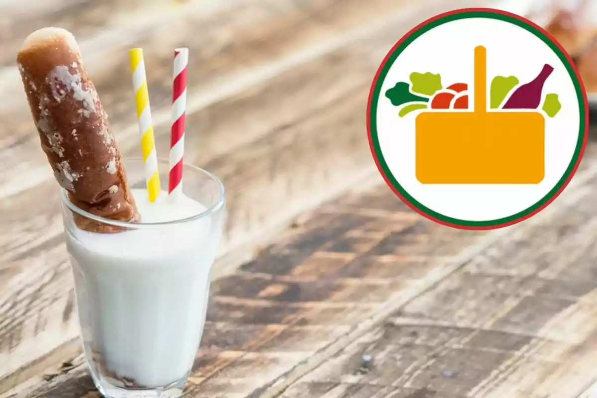Vaso de leche con un bolillo y dos popotes de colores sobre una mesa de madera junto a un logotipo de canasta con alimentos Vaso de leche con un bolillo y dos popotes de colores sobre una mesa de madera junto a un logotipo de canasta con alimentos