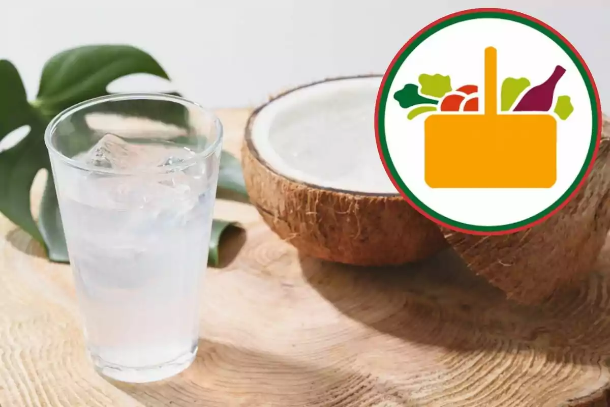 Vaso con agua de coco con hielo junto a un coco partido sobre una mesa de madera y un icono de canasta de supermercado Vaso con agua de coco con hielo junto a un coco partido sobre una mesa de madera y un icono de canasta de supermercado