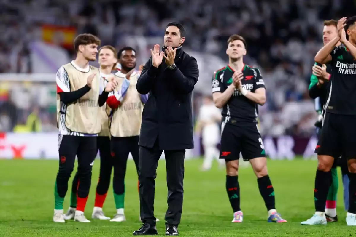 Entrenador y jugadores de un equipo de fútbol aplaudiendo en el campo después de un partido Entrenador y jugadores de un equipo de fútbol aplaudiendo en el campo después de un partido