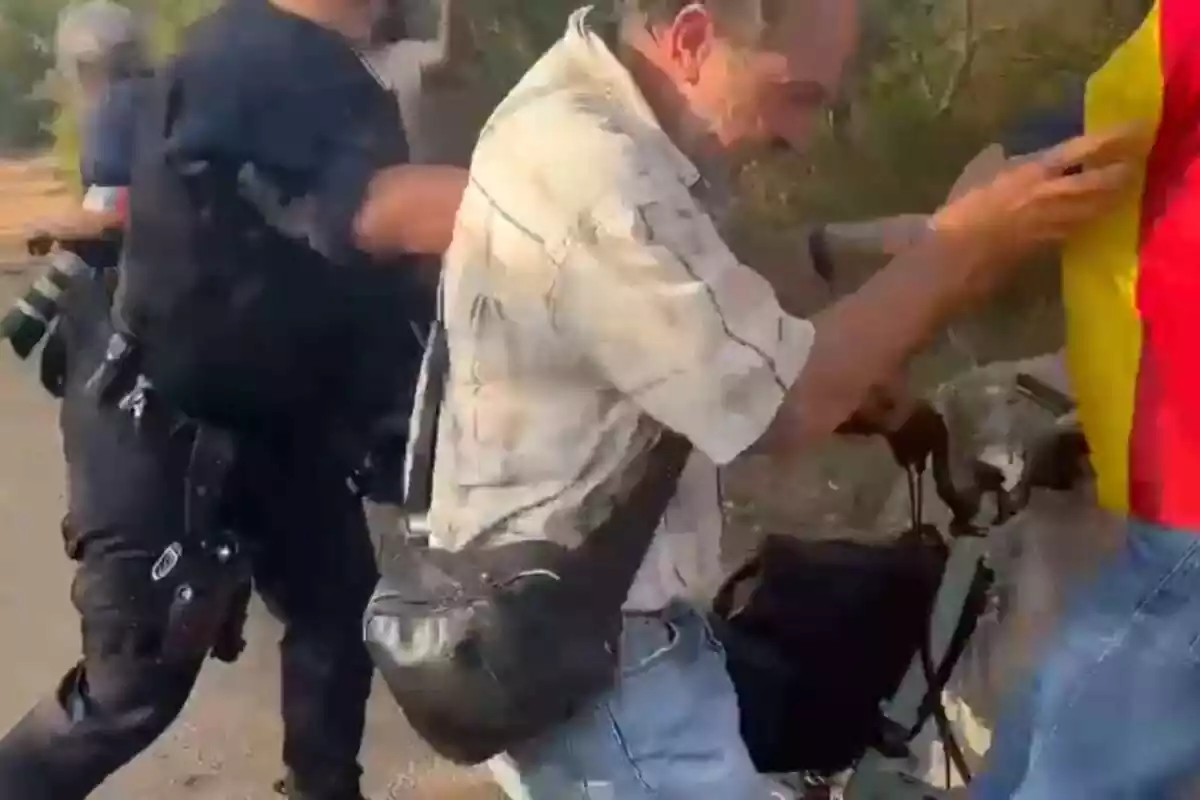 Captura del vídeo del momento en que una fuerza de seguridad empuja a un ciudadano con una camiseta ideológica catalana