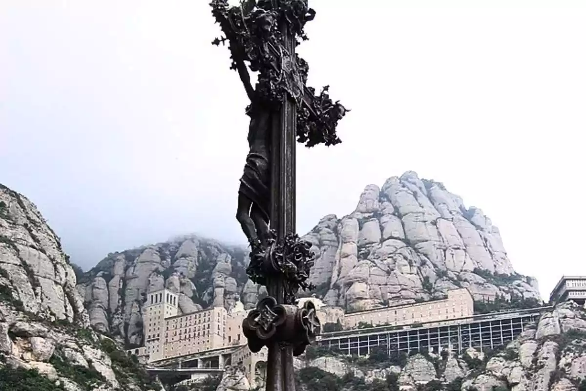 Crucifijo de la montaña de Montserrat con el monasterio de fondo