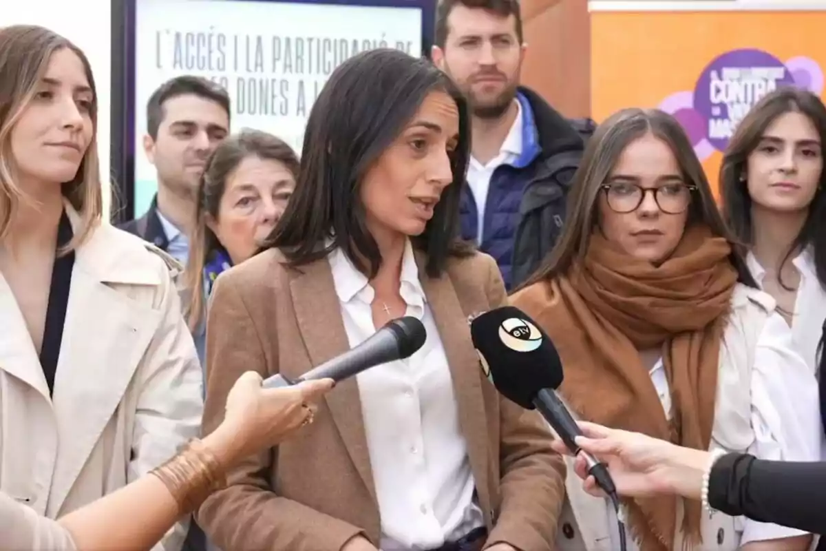 Un grupo de personas en una conferencia de prensa con micrófonos frente a ellos.