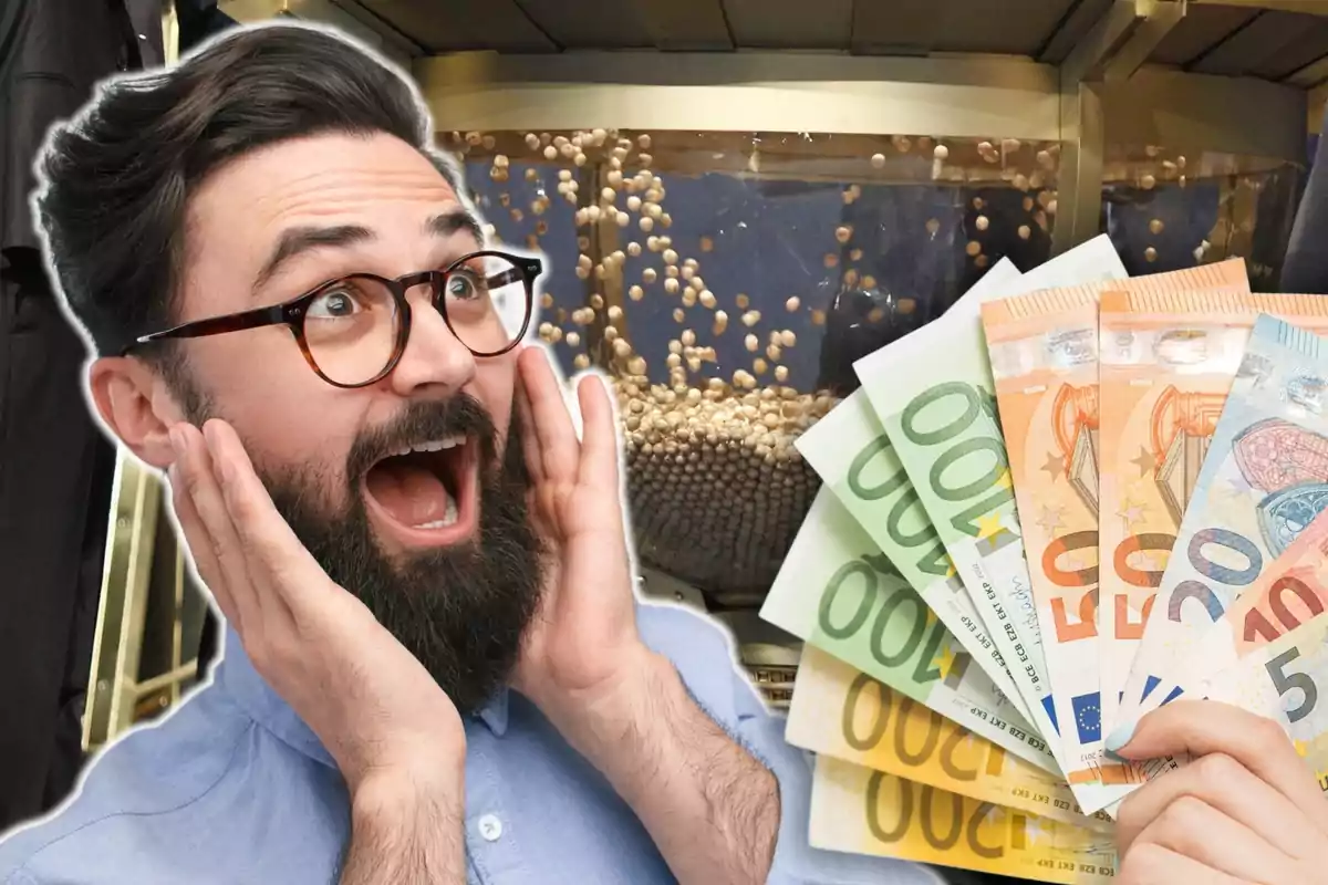 Un hombre con gafas y barba parece sorprendido mientras sostiene varios billetes de euro frente al bombo del sorteo de la Lotería de Navidad.