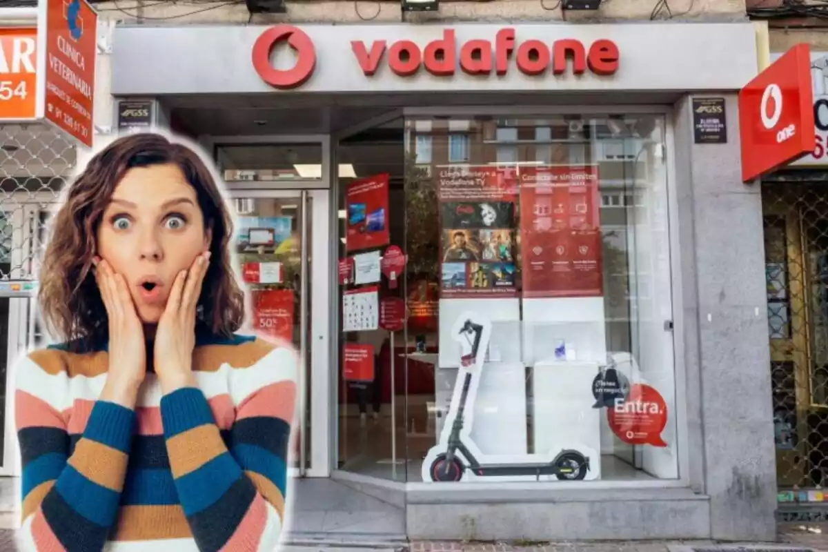 Una mujer con cara de asombro, en primer plano, y al fondo una tienda de Vodafone