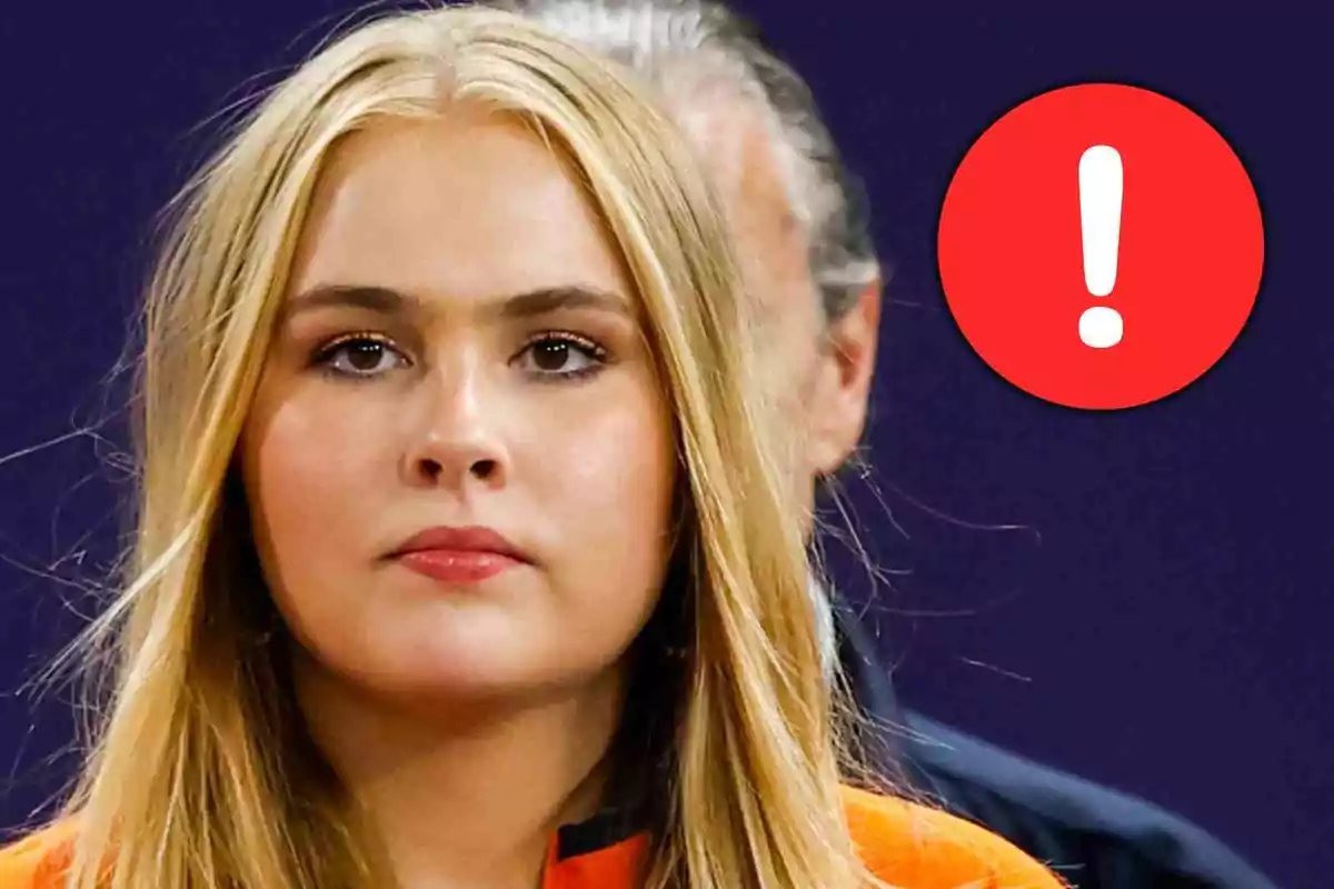 Amalia de Holanda con expresión seria y un círculo rojo con un signo de exclamación blanco al fondo