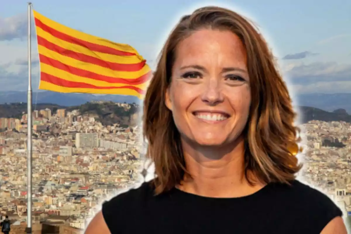 Primer plano de María Casado sonriente con cabello castaño claro y una camiseta negra, con una bandera catalana ondeando y una vista panorámica de una ciudad en el fondo.