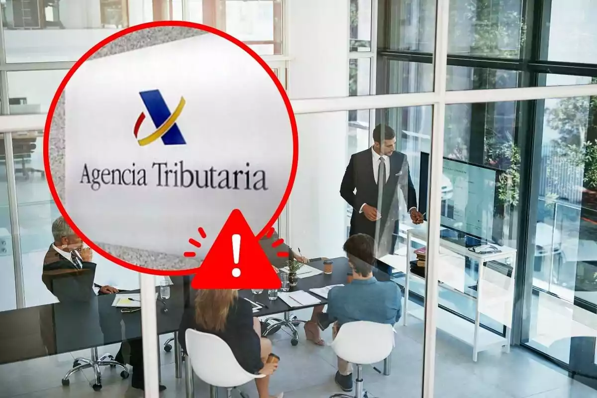 Una reunión de negocios en una oficina moderna con un aviso de la Agencia Tributaria en primer plano.