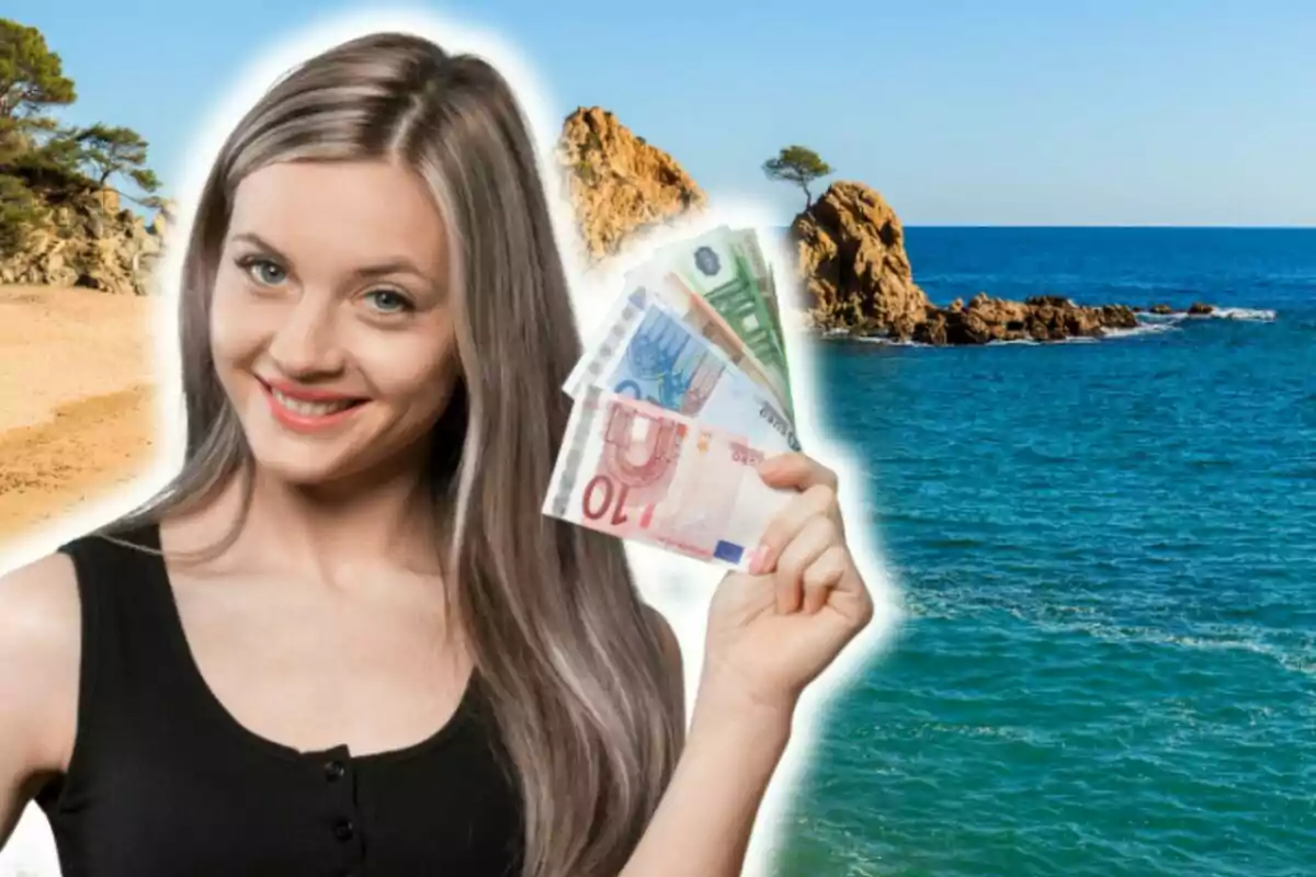 Una mujer sonriente sostiene billetes de euro con un fondo de Tossa de Mar donde se aprece la playa y el mar.