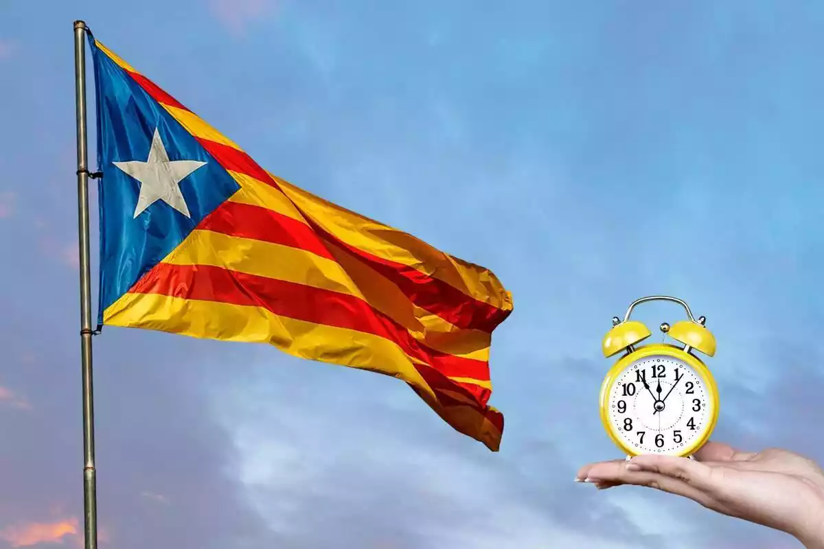 Imagen de una bandera independentista de Cataluña y, al lado, una mano sujetando un reloj