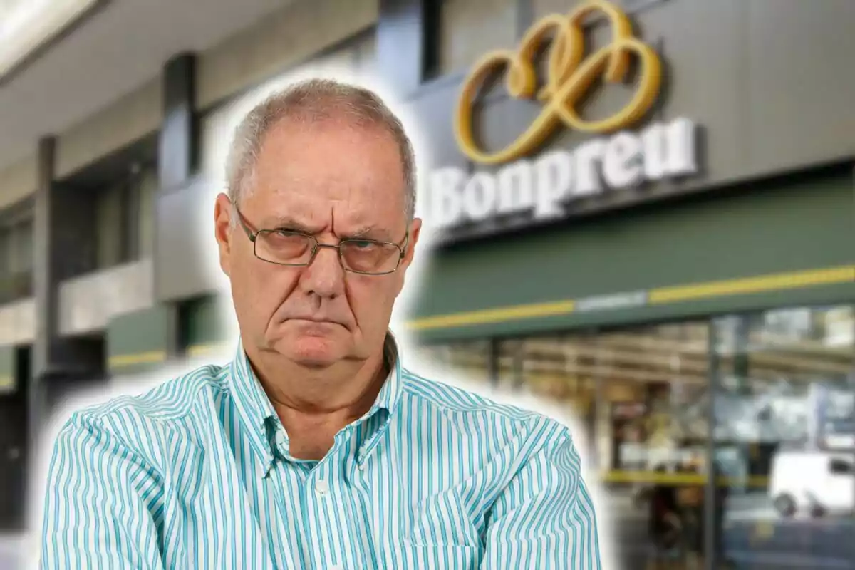 Un hombre mayor con expresión seria y camisa de rayas frente a una tienda Bonpreu.