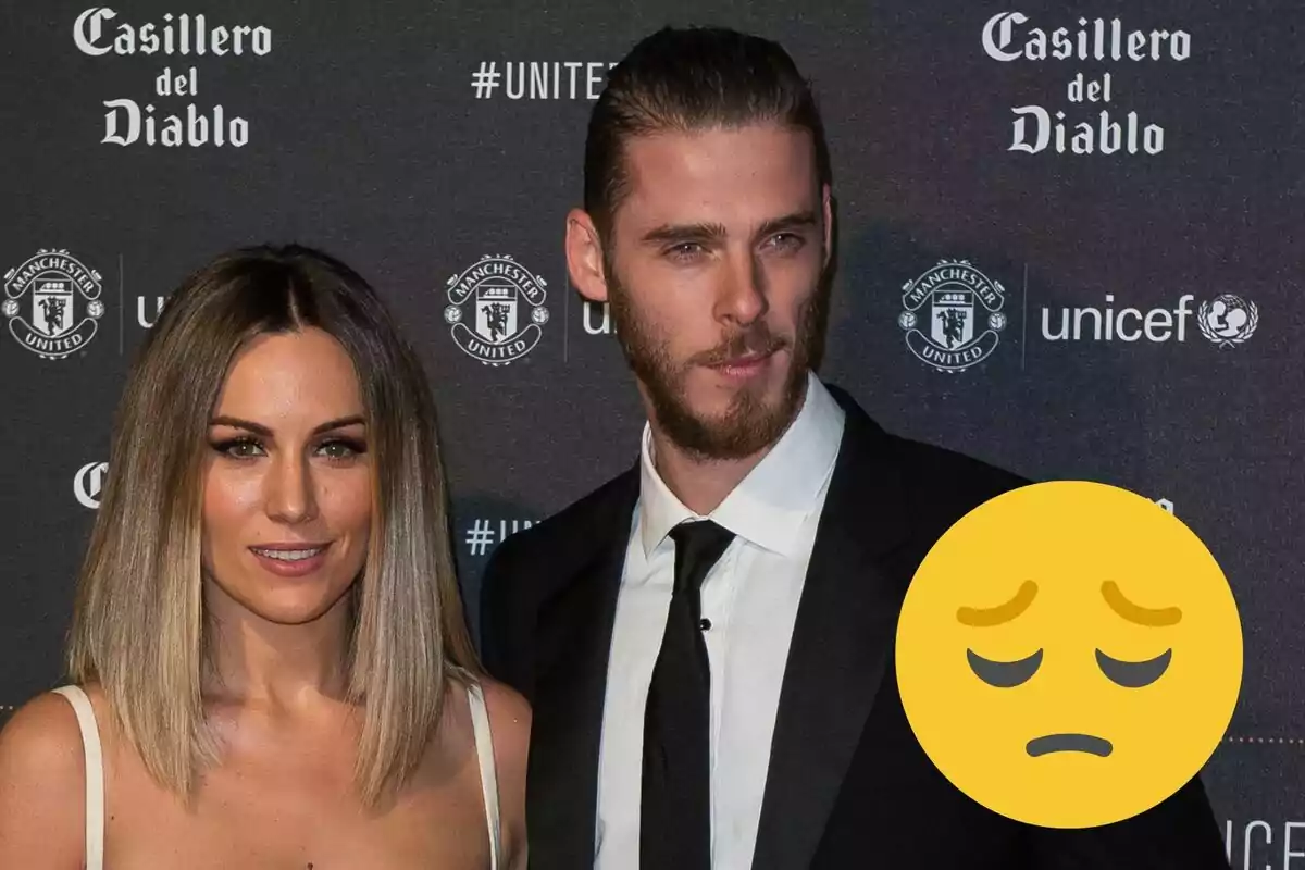 Edurne y David de Gea posando en un evento con un fondo que muestra los logotipos de Casillero del Diablo, Manchester United y UNICEF, con un emoji de cara pensativa superpuesto.