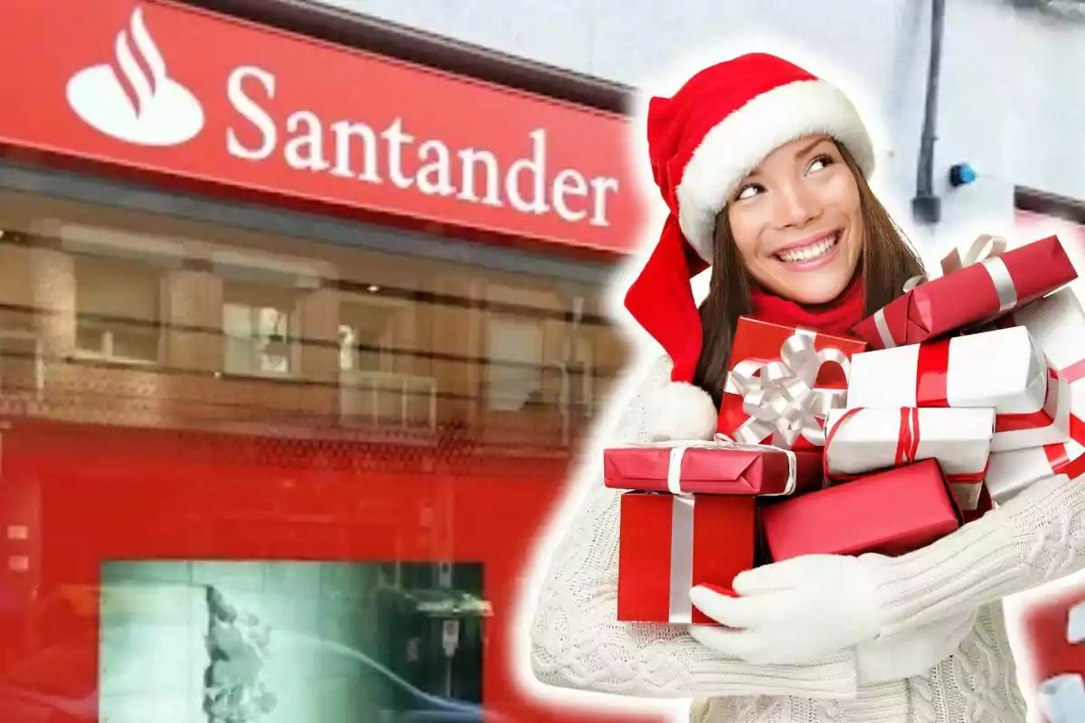 Una mujer sonriente con gorro de Navidad sostiene varios regalos frente a una sucursal del banco Santander.