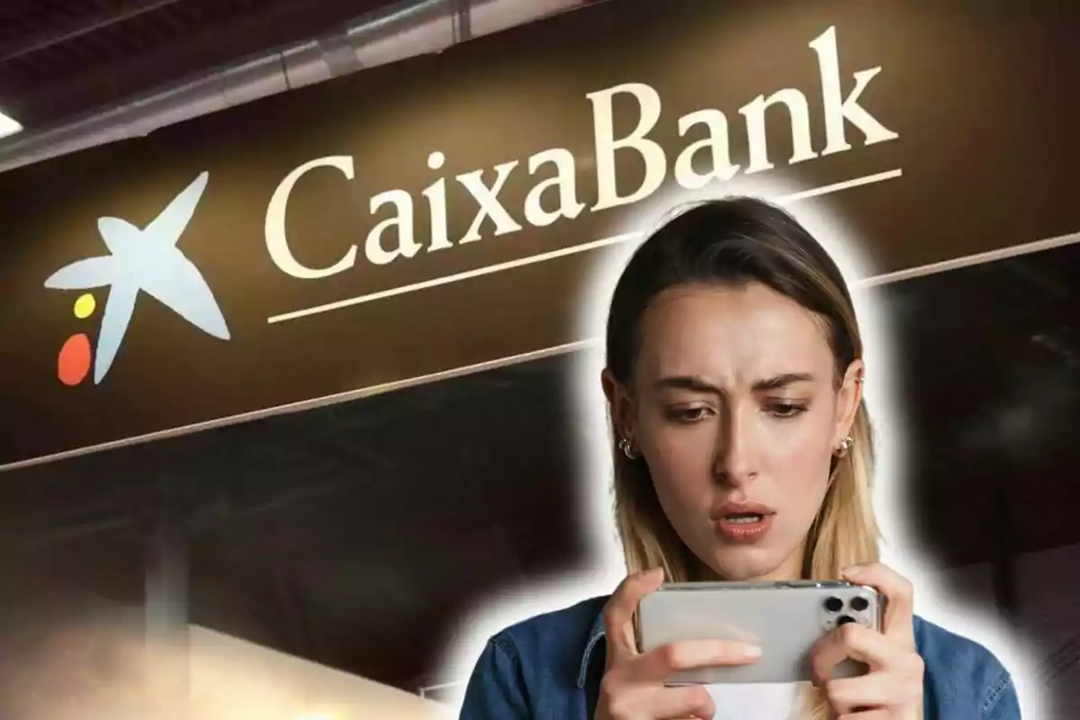 Una persona mirando su teléfono con expresión de sorpresa frente a un cartel de CaixaBank.