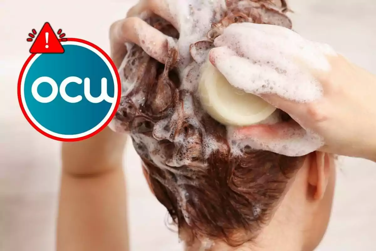 Persona lavándose el cabello con jabón mientras se genera espuma y aparece un logotipo de la OCU con un signo de advertencia.