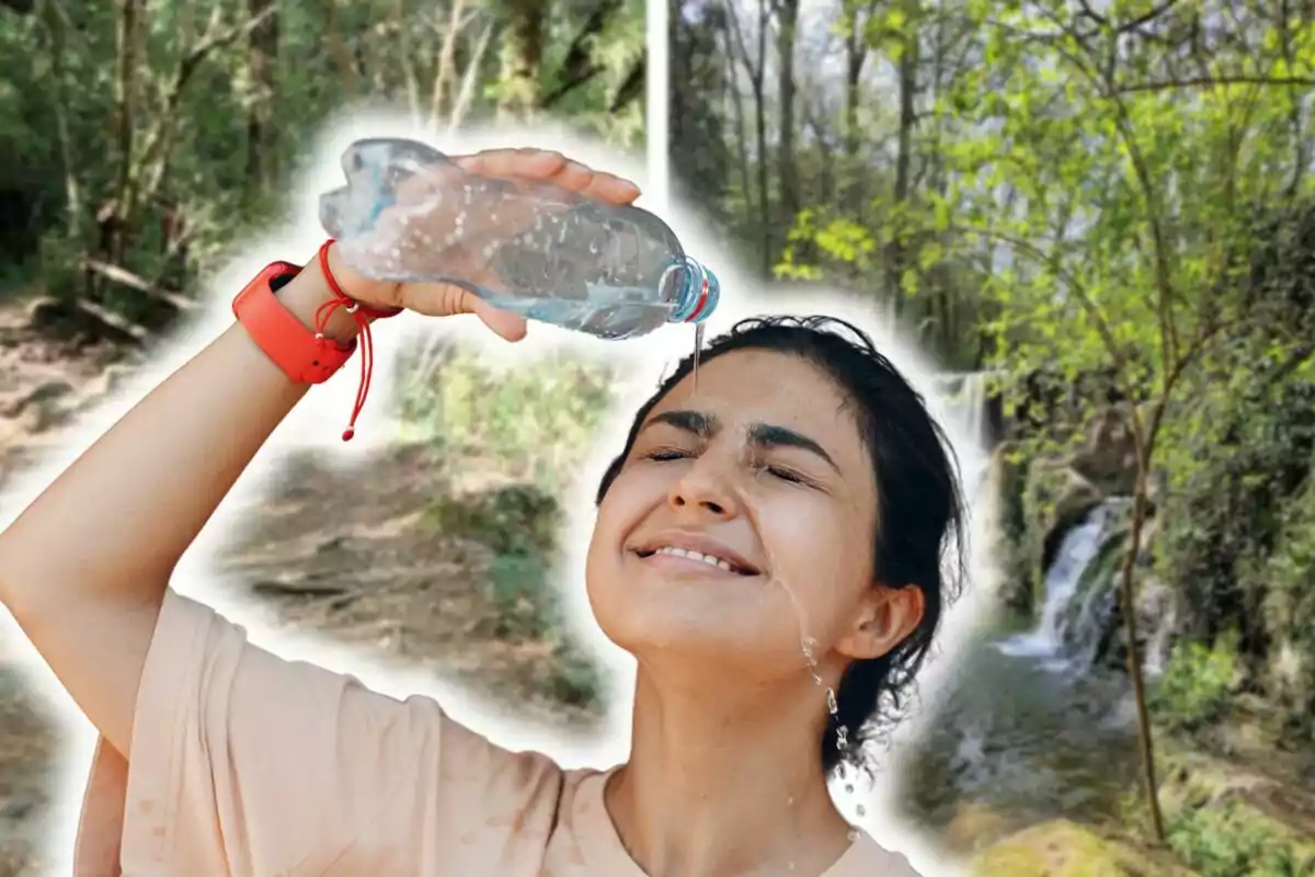 Una persona se refresca con agua en el rostro mientras disfruta de un entorno natural con árboles y una cascada.