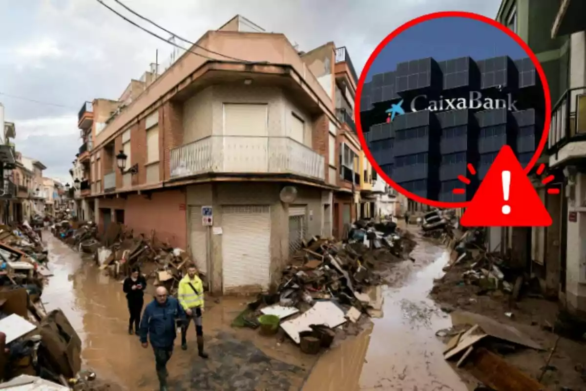 Personas caminando por una calle inundada y llena de escombros con un edificio de CaixaBank resaltado en un círculo rojo con un signo de advertencia.