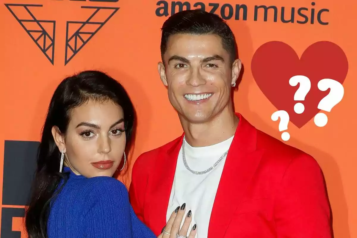 Georgina Rodríguez y Cristiano Ronaldo posando en un evento con un fondo naranja y un logotipo de Amazon Music, con un corazón y signos de interrogación al lado.