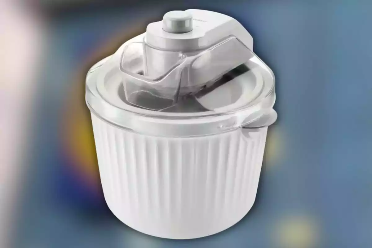 Máquina para hacer helados de color blanco con tapa transparente sobre un fondo desenfocado. Máquina para hacer helados de color blanco con tapa transparente sobre un fondo desenfocado.