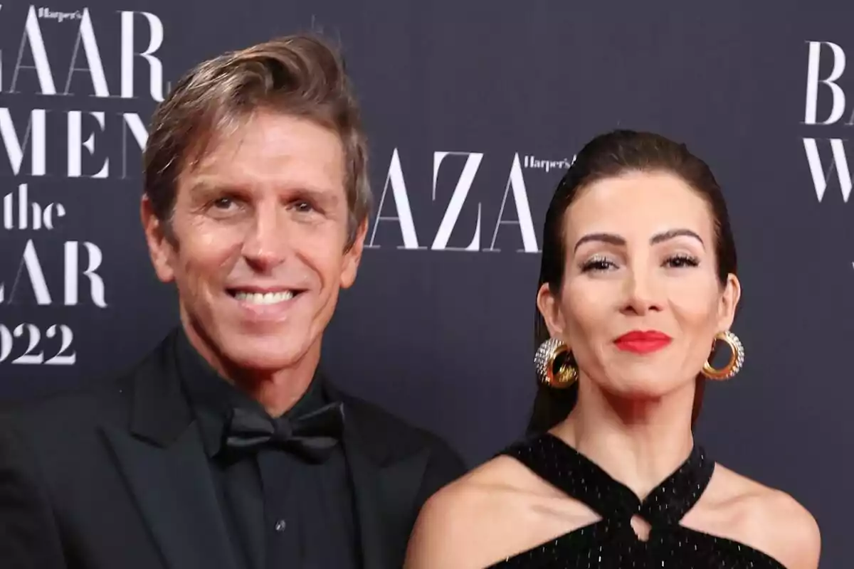 Manuel Díaz y Virginia Troconis posando en un evento de gala con fondo de la revista Harper's Bazaar.