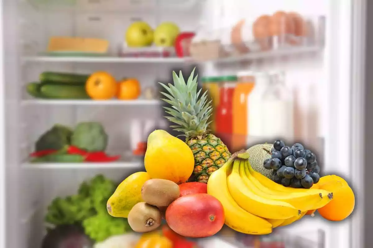 Montaje con una nevera abierta y llena de comida de fondo, y varias frutas amontonadas en primer plano