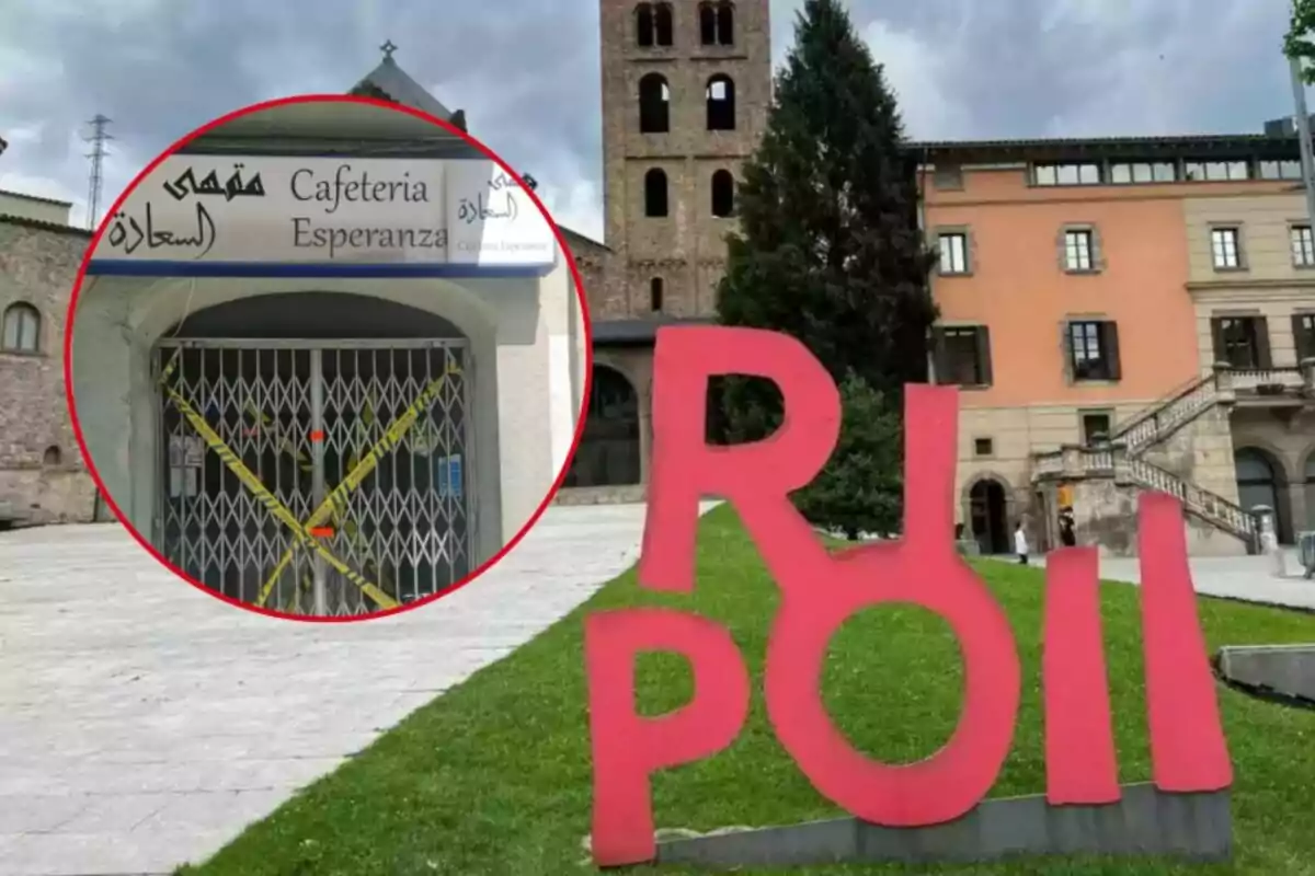 Una cafetería cerrada con cinta de precaución y una estructura de letras rojas en un área urbana con edificios históricos de fondo.
