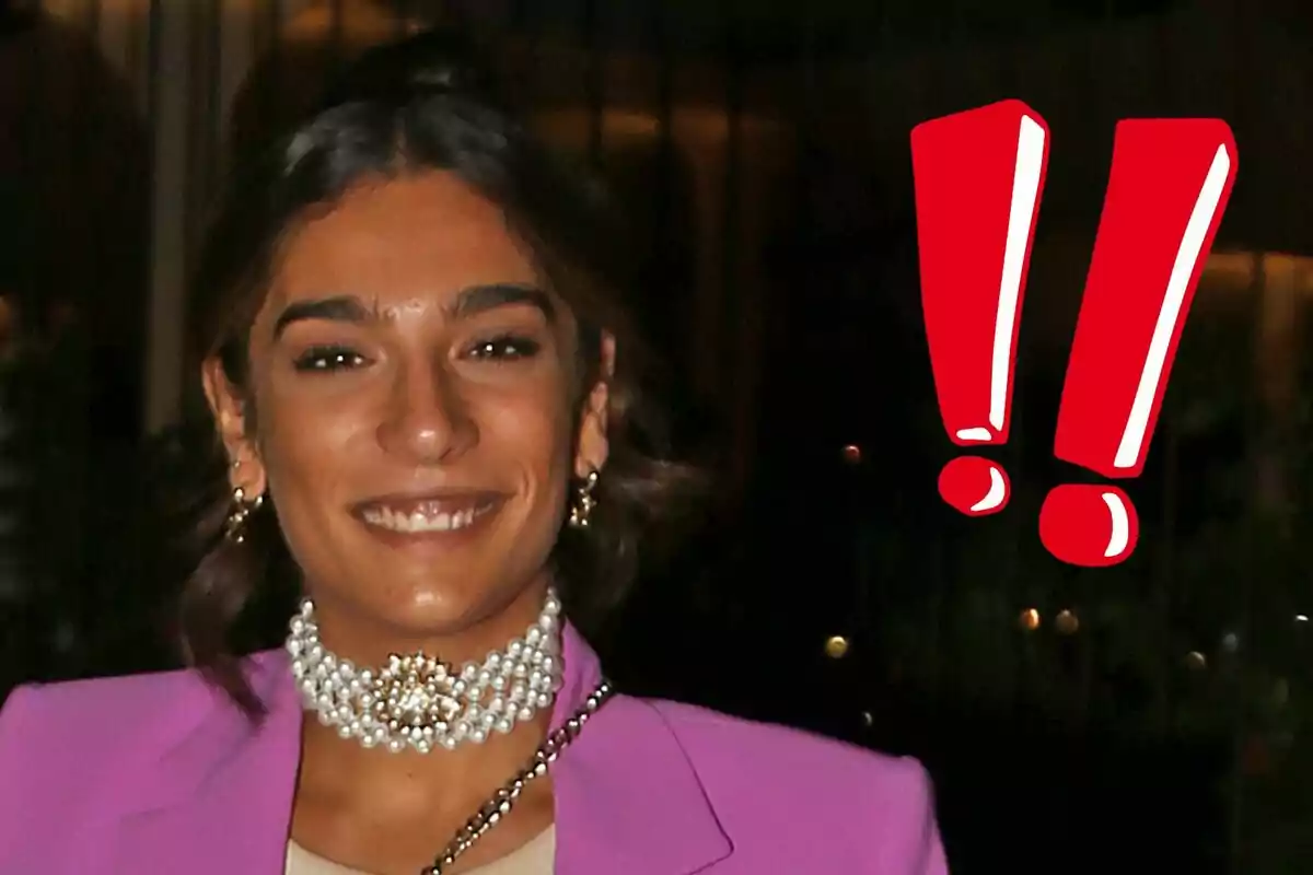 Alma Bollo sonriendo con un traje rosa y un collar de perlas junto a dos signos de exclamación rojos.