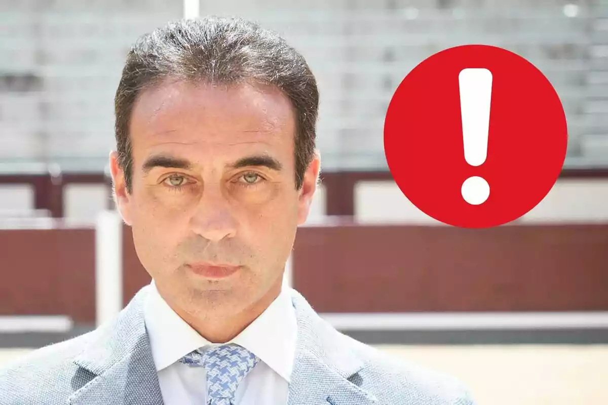 Enrique Ponce de traje con un símbolo de exclamación rojo al lado.