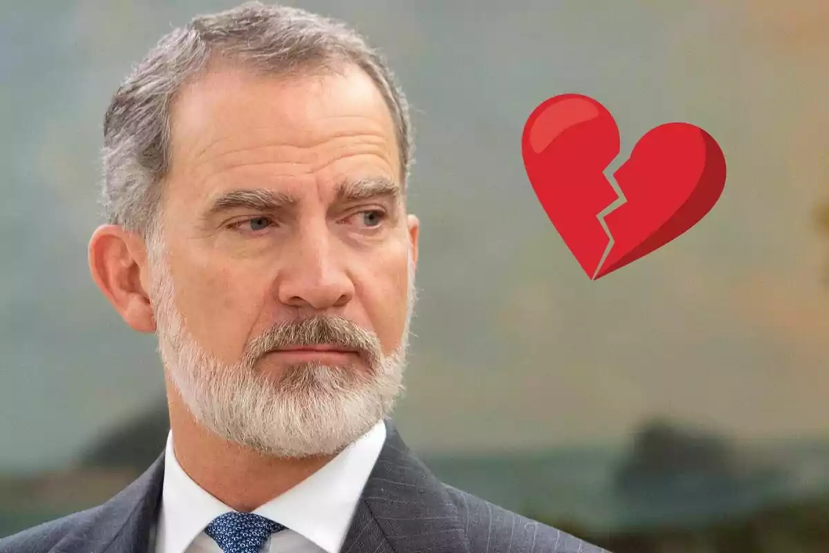 Felipe VI con expresión seria y un corazón roto rojo dibujado a su lado
