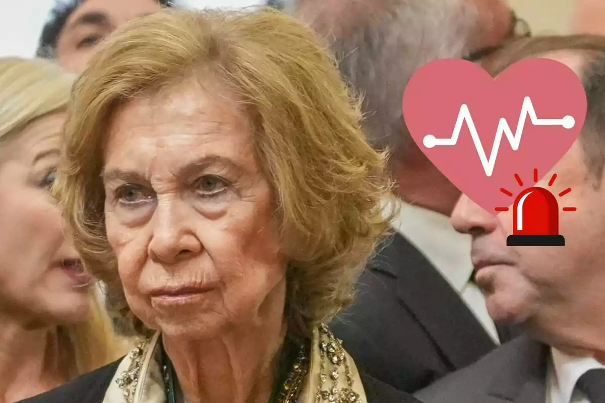 La reina Sofía con expresión seria en un evento, con un gráfico de corazón y alerta superpuesto.