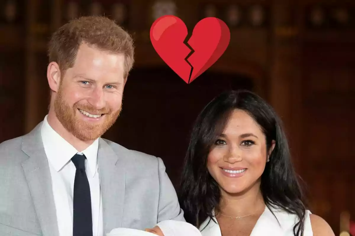 El príncipe Harry y Meghan Markle sonriente sostiene a un bebé mientras un corazón roto flota sobre ellos.