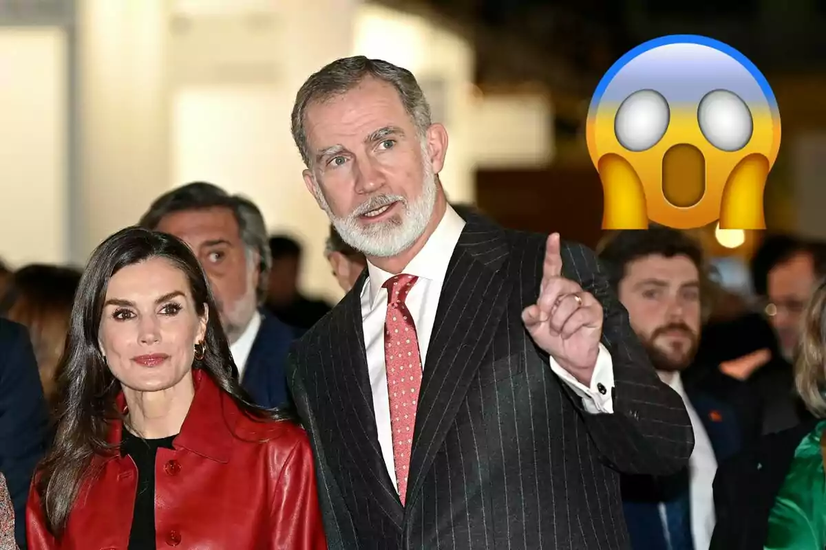 La reina Letizia y Felipe VI elegantemente vestida en un evento, con un emoji sorprendido en la esquina superior derecha.