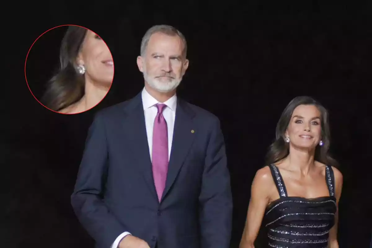 El rey Felipe VI y la reina Letizia elegantemente vestida camina en un evento nocturno, con un enfoque en los pendientes brillantes de la mujer.