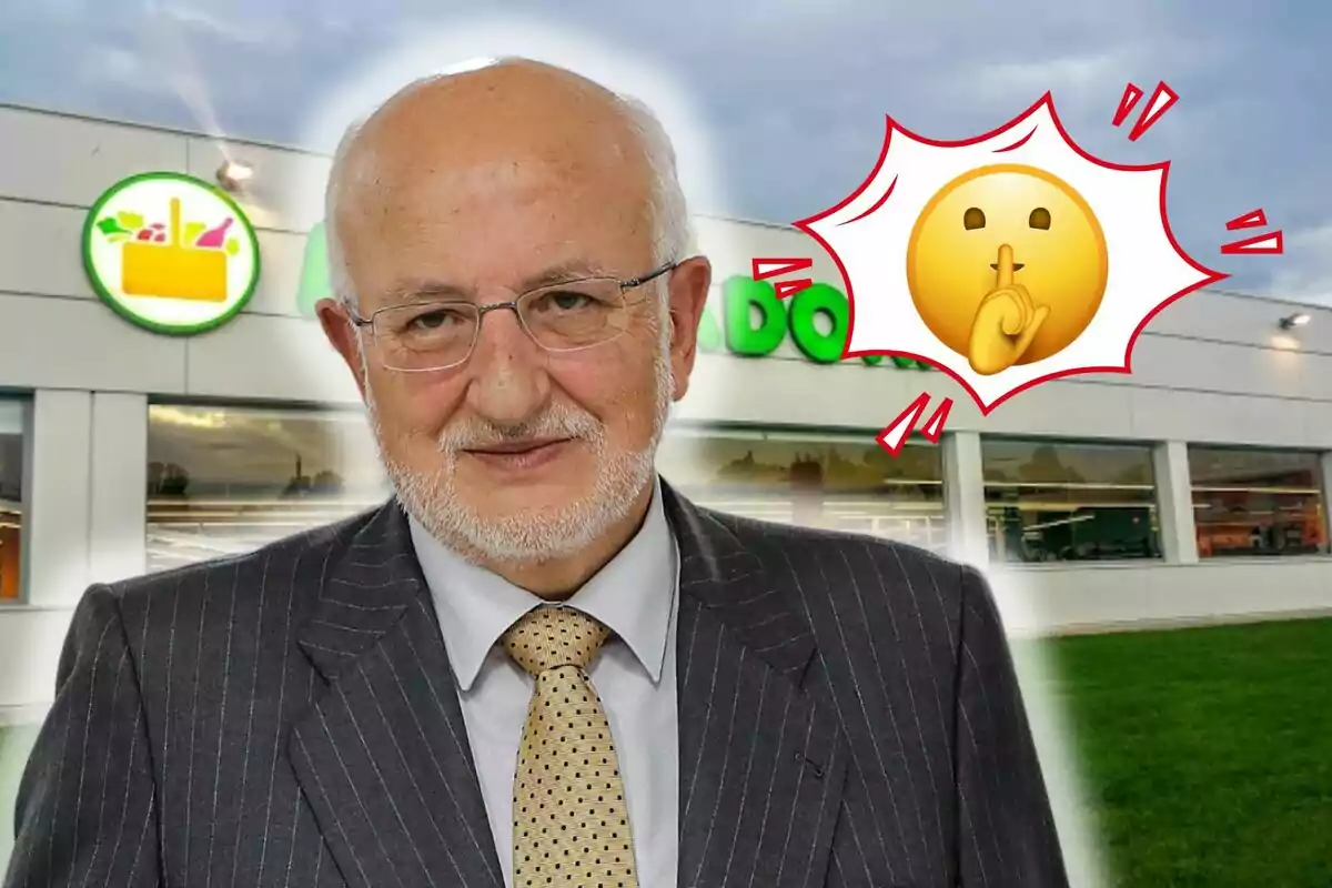 Juan Roig con traje y corbata está frente a un edificio con un logotipo verde y un emoji de silencio al lado.