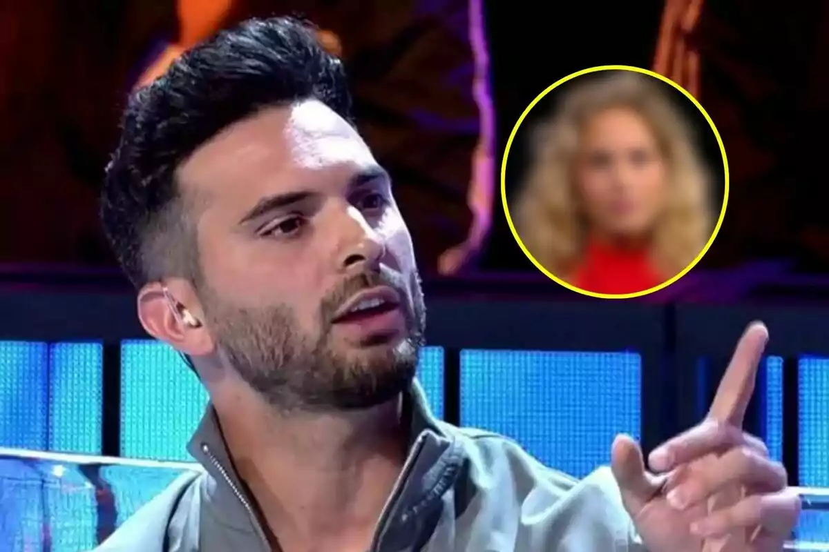 Suso Álvarez con barba y cabello oscuro está hablando y gesticulando en el debate de Gran hermano con una imagen borrosa de la concursante Violeta en un círculo amarillo en el fondo.