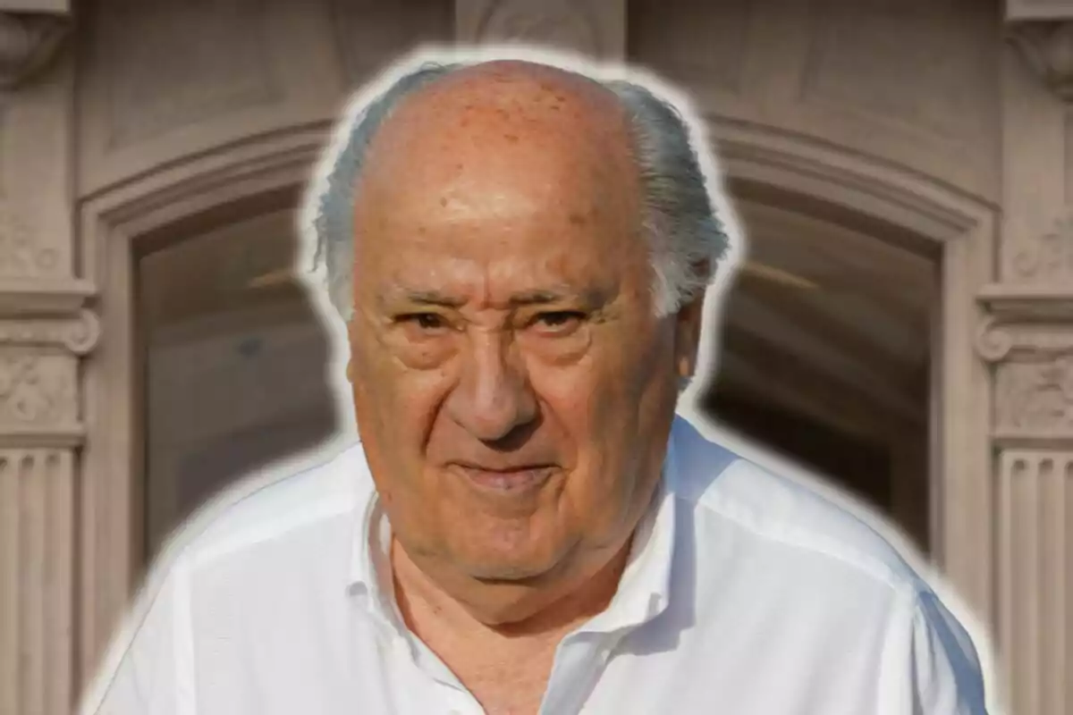 Amancio Ortega con camisa blanca frente a un edificio con detalles arquitectónicos.